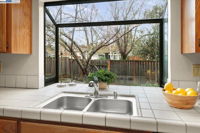 kitchen with plenty of natural light, sink, and tile countertops