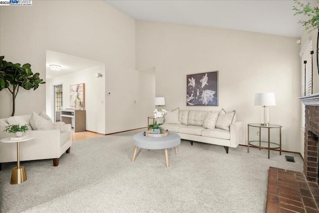 carpeted living room featuring high vaulted ceiling and a brick fireplace