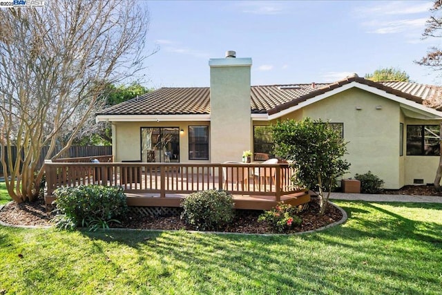 back of property with a wooden deck and a yard