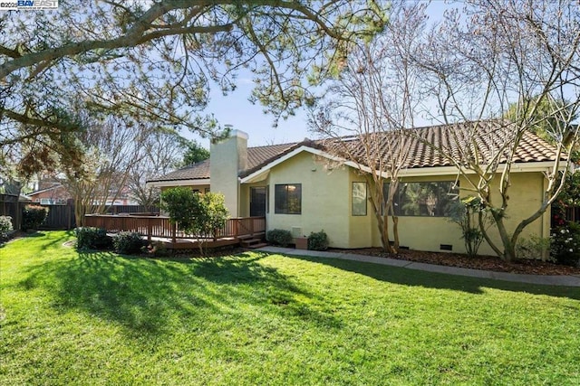 rear view of property featuring a yard and a deck