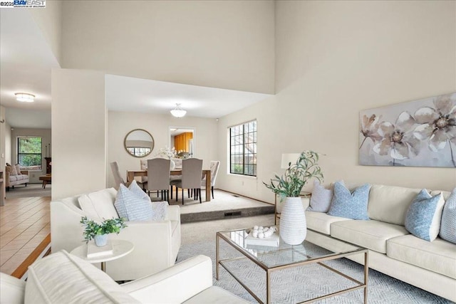 tiled living room with plenty of natural light and a towering ceiling