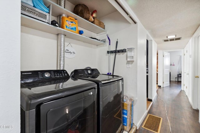 laundry area featuring independent washer and dryer, dark hardwood / wood-style floors, and a textured ceiling