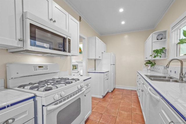 kitchen featuring sink, crown molding, white appliances, tile counters, and white cabinets