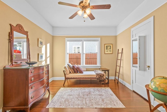 living area with wood-type flooring and ceiling fan