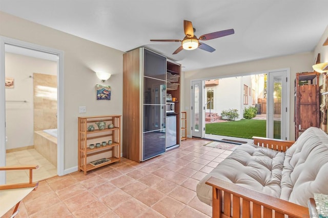 living area with light tile patterned floors and ceiling fan