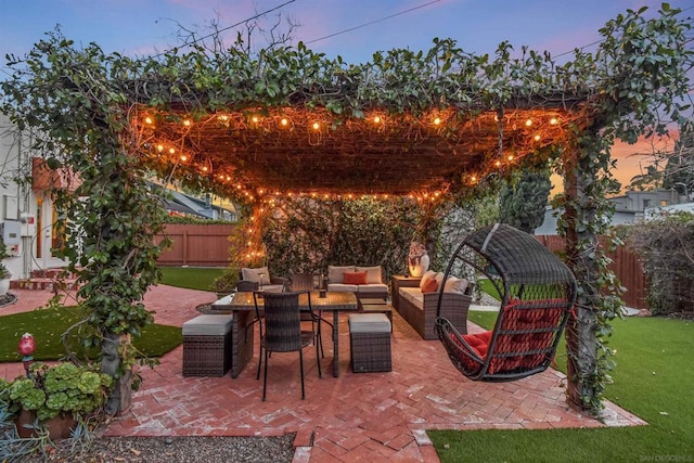 patio terrace at dusk with an outdoor living space and a lawn