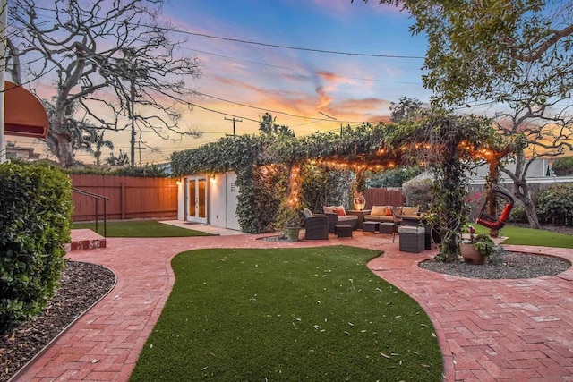 yard at dusk featuring an outdoor living space and a patio area