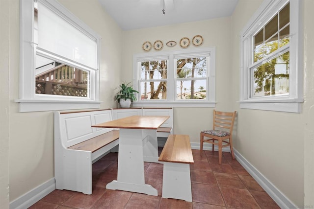 dining space with breakfast area, plenty of natural light, and dark tile patterned flooring