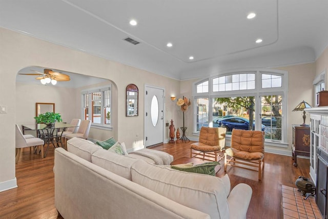 living room featuring ornamental molding, dark wood-type flooring, and ceiling fan