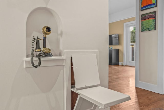 corridor with hardwood / wood-style flooring