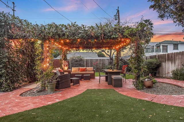 patio terrace at dusk with a yard and outdoor lounge area