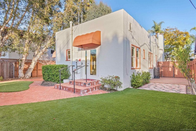 back of property with a patio area and a lawn