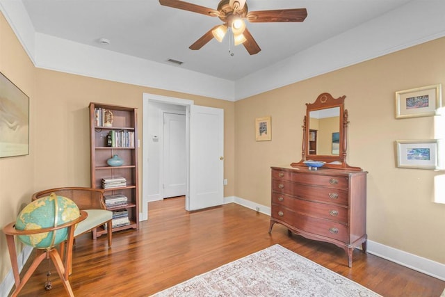 sitting room featuring wood-type flooring and ceiling fan