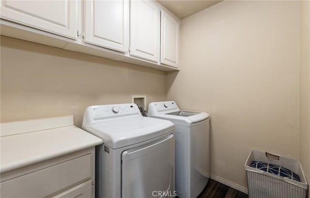 laundry room with baseboards, dark wood finished floors, cabinet space, and washer and dryer