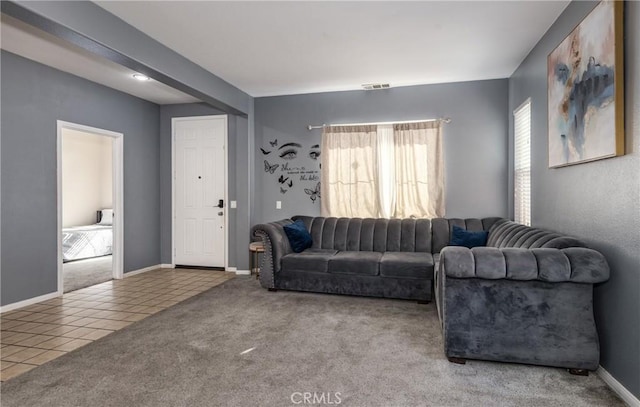 carpeted living area featuring tile patterned flooring, visible vents, and baseboards