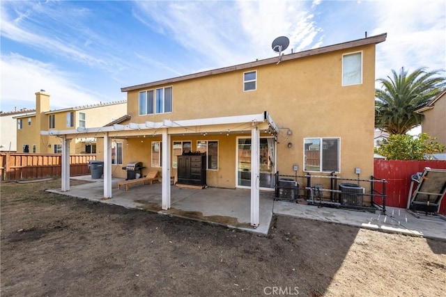 back of house featuring a fenced backyard, a patio, central AC, and stucco siding