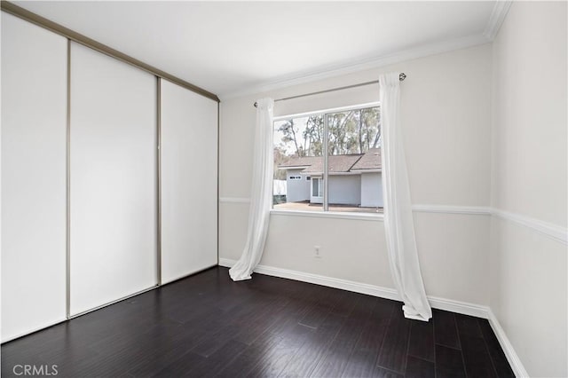 unfurnished bedroom featuring ornamental molding, wood-type flooring, and a closet