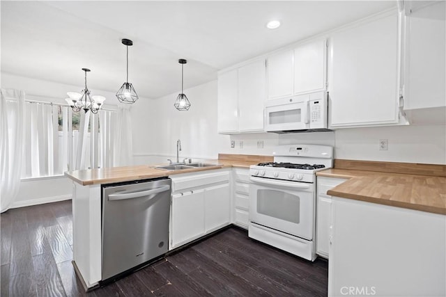 kitchen featuring white cabinetry, hanging light fixtures, white appliances, and kitchen peninsula