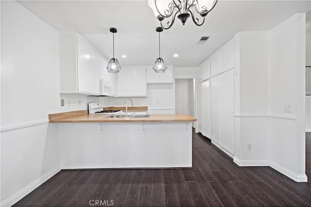 kitchen featuring pendant lighting, dark wood-type flooring, white cabinetry, stove, and kitchen peninsula