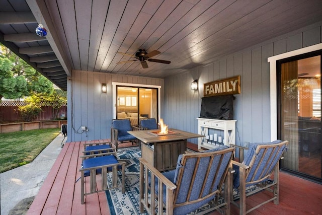 wooden deck featuring ceiling fan and an outdoor fire pit