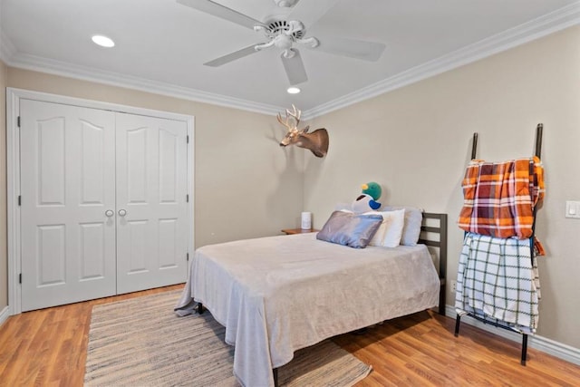 bedroom featuring hardwood / wood-style floors, crown molding, a closet, and ceiling fan