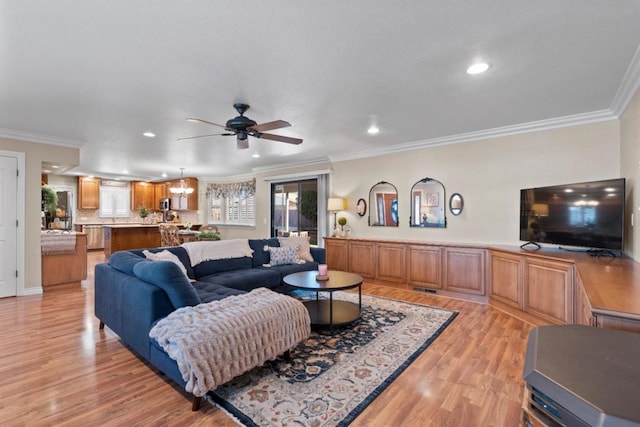 living room with crown molding, ceiling fan with notable chandelier, and light hardwood / wood-style flooring