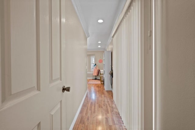 corridor featuring ornamental molding and light hardwood / wood-style floors