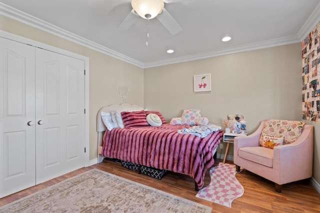 bedroom featuring hardwood / wood-style floors, crown molding, a closet, and ceiling fan