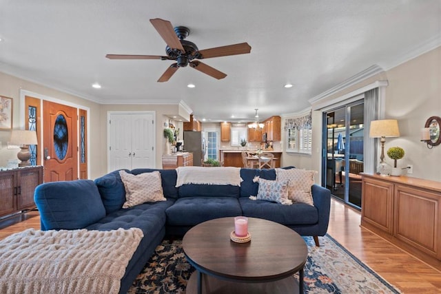 living room with crown molding, ceiling fan, and light hardwood / wood-style floors