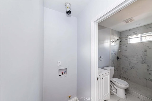 bathroom featuring tiled shower, vanity, and toilet