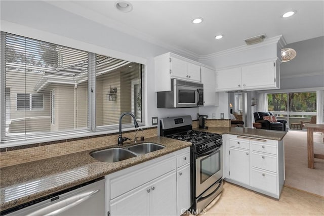 kitchen featuring white cabinetry, stainless steel appliances, sink, and dark stone counters