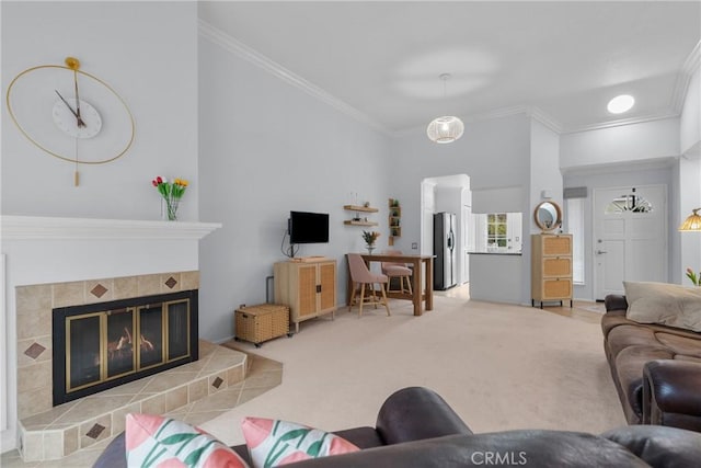 carpeted living room featuring a tiled fireplace and ornamental molding