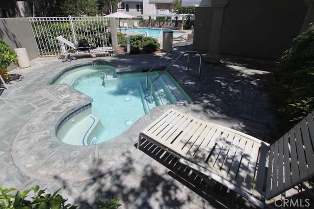 view of swimming pool with a community hot tub and a patio