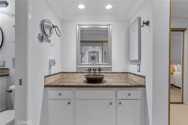 bathroom with ornamental molding, toilet, and vanity