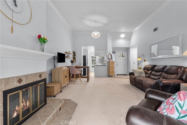 carpeted living room with a tiled fireplace and crown molding