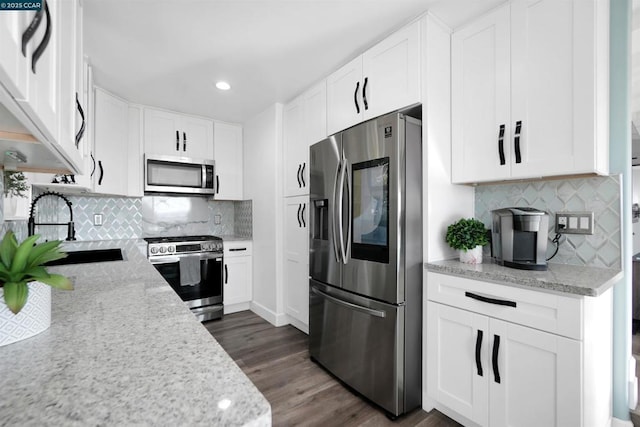 kitchen with appliances with stainless steel finishes, sink, and light stone counters