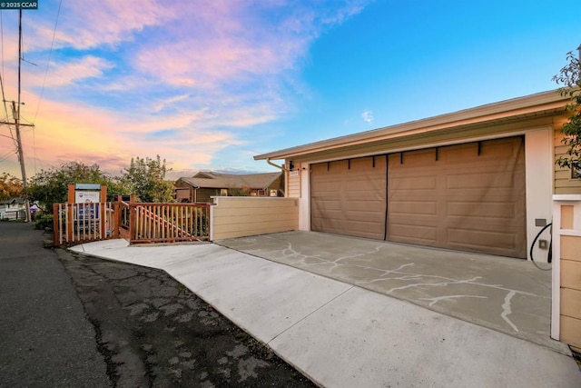 view of garage at dusk