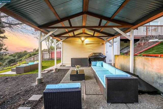 patio terrace at dusk featuring a grill and outdoor lounge area