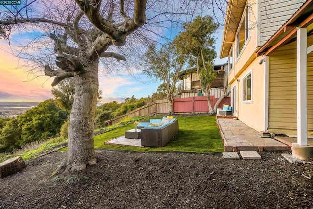 yard at dusk featuring outdoor lounge area and a patio