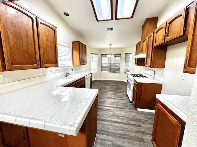 kitchen featuring pendant lighting, sink, white appliances, and tile countertops