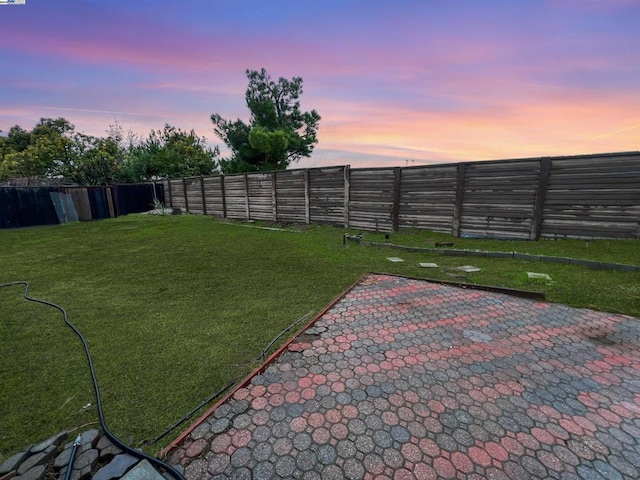 yard at dusk featuring a patio area