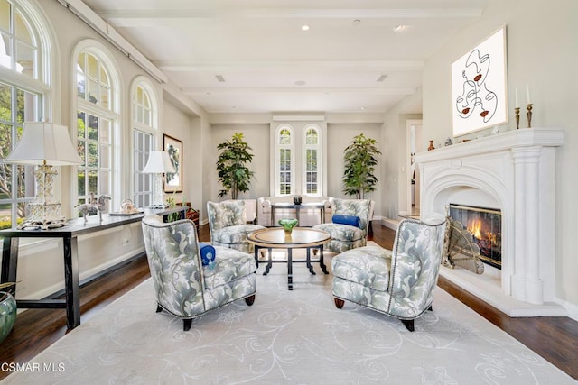 sitting room with hardwood / wood-style flooring, plenty of natural light, and beam ceiling