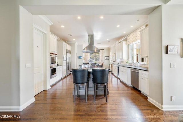 kitchen featuring white cabinetry, island exhaust hood, appliances with stainless steel finishes, and a center island