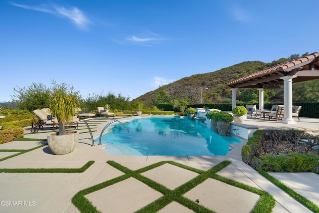 view of pool with a patio and a mountain view