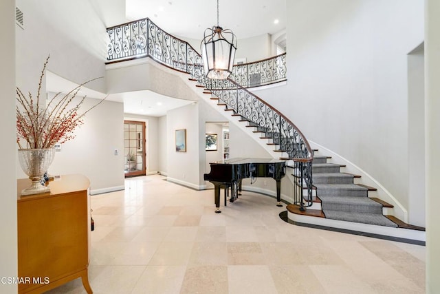 entryway featuring a notable chandelier and a towering ceiling