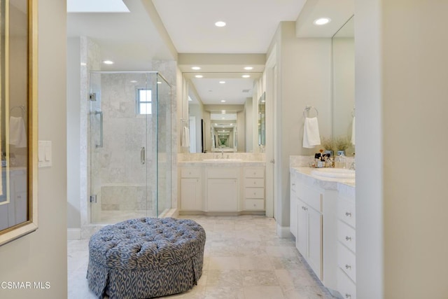 bathroom with walk in shower and vanity