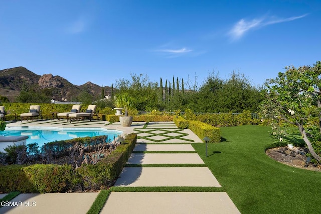 view of property's community with a pool, a mountain view, and a lawn