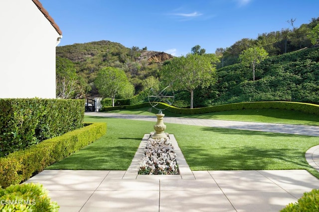 surrounding community with a mountain view and a yard