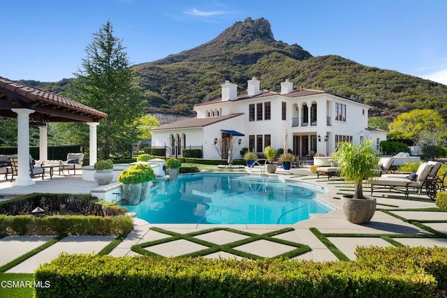 rear view of house with a mountain view and a patio area