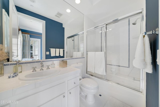 full bathroom featuring vanity, combined bath / shower with glass door, and toilet